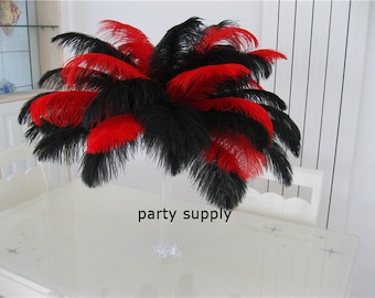 May include: A vase filled with black and red ostrich feathers. The feathers are arranged in a fan shape and are a popular party supply.