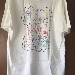 May include: White t-shirt with colorful drawings and signatures, including "Steve Tyler" and "Black Sabbath".