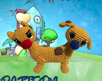 May include: Crochet pattern for a two-headed dog with brown and tan fur, brown spots, and blue and red noses. The dog is sitting on a green grassy surface with a cartoon house in the background. The text "Dipped In Ink Crochet" is at the top of the image and the text "PATTERN" is at the bottom of the image.