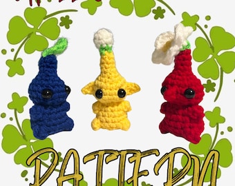 Puede incluir: Patrón de crochet para tres personajes amigurumi. Los personajes son azul, amarillo y rojo. Los personajes tienen ojos grandes y están de pie sobre un fondo verde con hojas de trébol.