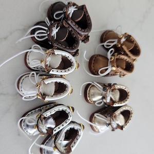 May include: A set of three ceramic mugs with a speckled, matte finish. The mugs are in shades of cream, light gray, and dark gray. Each mug has a simple, minimalist design, perfect for coffee or tea.