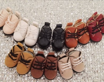 May include: A collection of miniature doll shoes in various colors, including pink, white, black, brown, and red. The shoes are arranged in rows and feature laces and detailed stitching, perfect for doll enthusiasts.