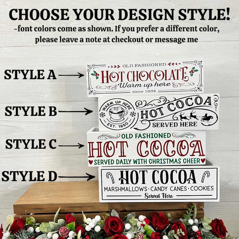 May include: Four different styles of white wooden signs with red, green, and black lettering. The signs advertise "Hot Cocoa" with different variations of the text and graphics. The signs are stacked on top of each other.