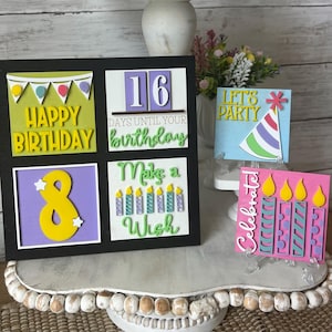 Puede incluir: Una colección de coloridas decoraciones de cumpleaños de madera. El conjunto incluye una pieza enmarcada en negro con los textos "Happy Birthday", "16 días para tu cumpleaños", "8" y "Make a Wish". Piezas adicionales dicen "Let's Party" y "Celebrate".