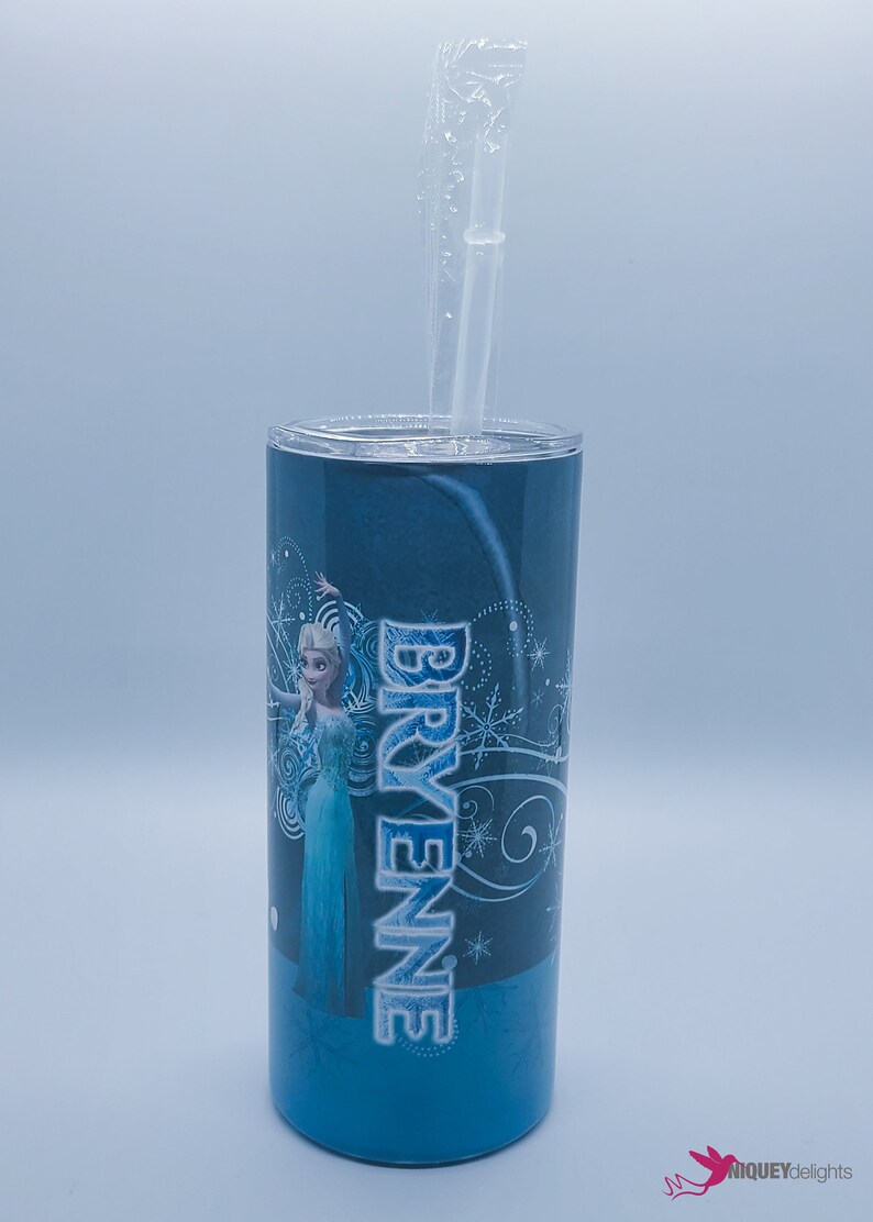 K&ouml;nnte beinhalten: Ein blauer Becher mit Deckel und einem durchsichtigen Strohhalm. Der Becher zeigt ein Design einer Figur aus dem Film Frozen, mit dem Namen "BRYENNE" in Wei&szlig;. Der Hintergrund ist ein Blauton.