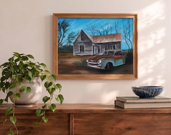 May include: A framed painting depicting a weathered, light-colored wooden house with a rusty roof and a vintage, teal-colored car parked in front. The scene is set against a bright blue sky with bare trees, capturing a rural landscape in a realistic style.