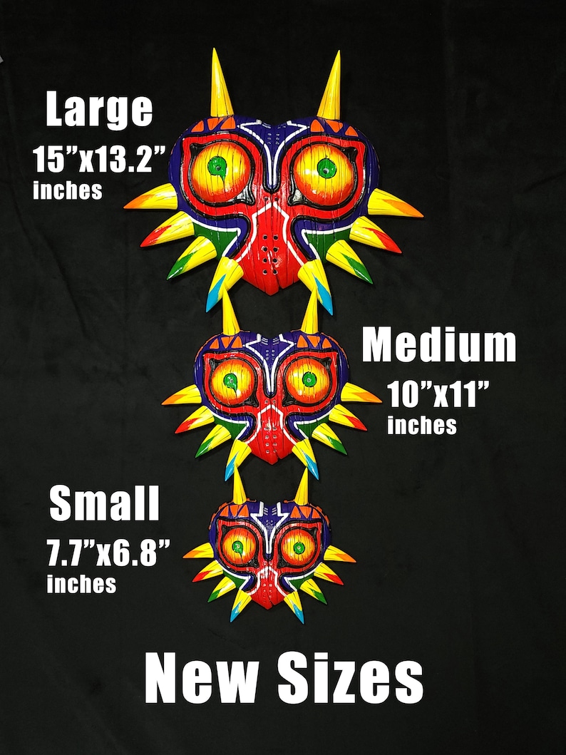 May include: Three different sizes of a Majora's Mask from The Legend of Zelda video game. The masks are made of wood and painted in bright colors, including red, yellow, green, blue, and purple. The masks are arranged from largest to smallest, with the largest mask measuring 15 inches by 13.2 inches, the medium mask measuring 10 inches by 11 inches, and the smallest mask measuring 7.7 inches by 6.8 inches.