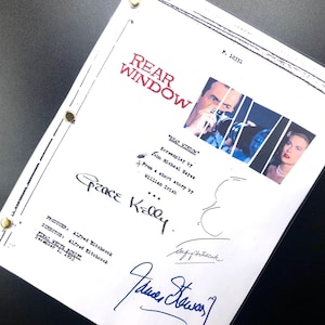 May include: A white script page for the movie "Rear Window" with the title in red. The page includes images from the film, signatures, and text. The script is held together with brass fasteners.