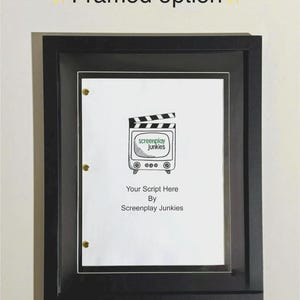 May include: A framed document with a black frame. The document features a film clapperboard design with the text "screenplay junkies" and the words "Your Script Here By Screenplay Junkies". The frame is mounted on a white wall.
