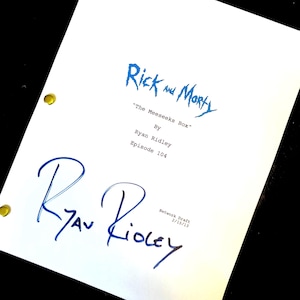 May include: A white script featuring the title "Rick and Morty" in blue, the episode title "The Meeseeks Box", and the author's name, Ryan Ridley. The script is signed by Ryan Ridley. The date 15/02/13 is also visible.