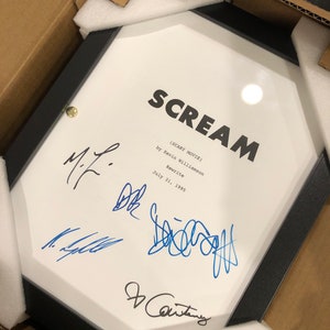 Könnte beinhalten: Ein gerahmtes Drehbuch für den Film "Scream" (Scary Movie) von Kevin Williamson, datiert auf den 31. Juli 1995. Das Drehbuch ist von vier Personen signiert, darunter der Autor.