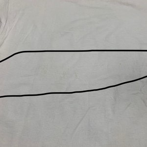 May include: A light gray t-shirt with a slightly wrinkled texture. The shirt is plain and has a simple design, suitable for casual wear. The fabric appears to be soft and lightweight.