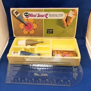 May include: A vintage sewing and marking kit by Salem Select, featuring a Mini Sew'R tool, a ruler, and two bottles of marking fluid. The box is yellow and green with the text "Mini Sew'R Sewing and Marking Kit" and "as seen on TV".