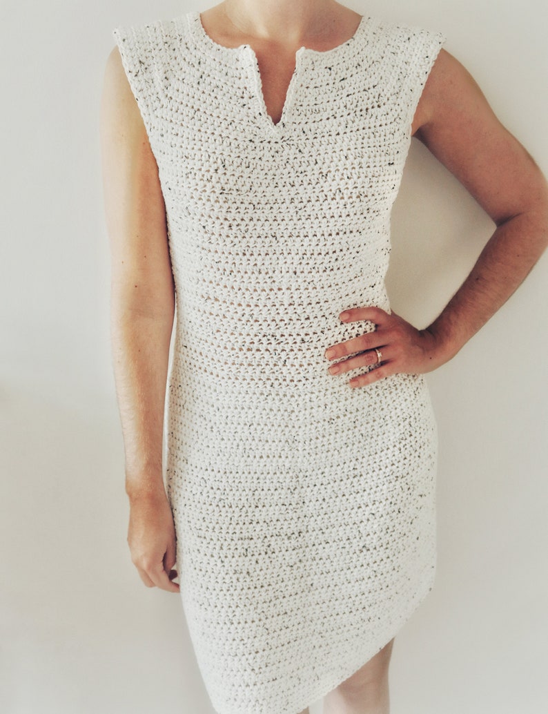 May include: A white crochet dress with a v-neck and sleeveless design.