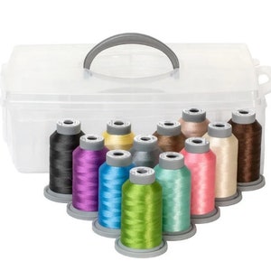 May include: A clear plastic storage box with a handle, containing 12 spools of colorful embroidery thread. The spools are arranged in a semi-circle, with the colors ranging from black to brown, yellow, green, blue, purple, and pink.