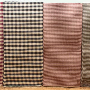 May include: Four folded fabric pieces with a checkered pattern. The colors include burgundy and cream, black and cream, red and cream, and black and cream. The fabric is likely cotton or linen.