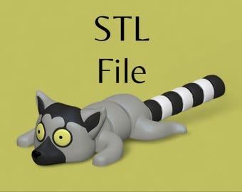 May include: A 3D printed model of a grey and black lemur with a striped tail. The lemur is lying on its side with its head resting on the ground. The model is labelled "STL File".