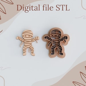May include: Two wooden mummy figures, one solid and one layered, with tan bandages and dark brown outlines. The text "Digital file STL" is at the top. The figures are on a light background with abstract leaf and wave designs.