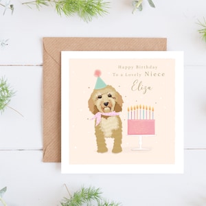 May include: A birthday card featuring a cartoon doodle dog wearing a party hat and holding a pink cake with lit candles. The card says "Happy Birthday To a Lovely Niece Eliza".