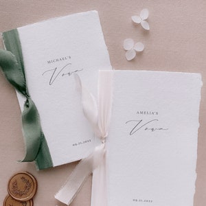 Set of 2 white handmade paper vow books printed with personalized names and date, tied in olive green and nude silk ribbons