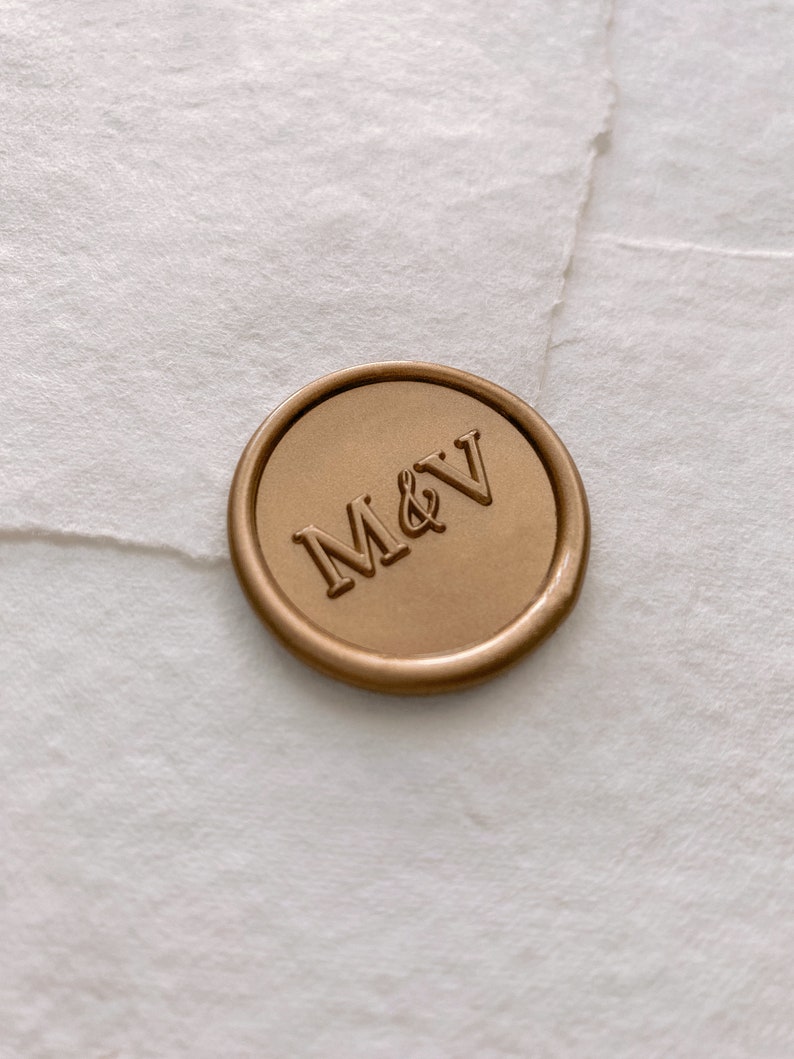 Monogram round wax seal in gold on white handmade paper envelope, side angle