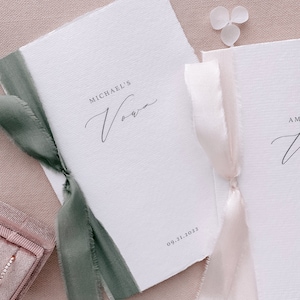 Set of 2 white handmade paper vow books printed with personalized names and date, tied in olive green and nude silk ribbons