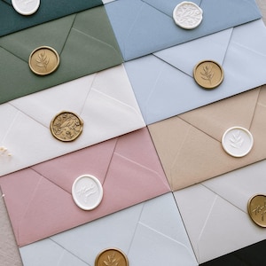 white and gold wax seals on envelopes in various colors