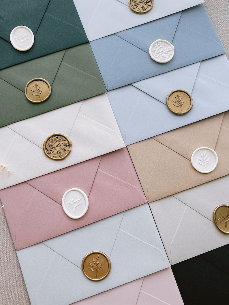 white and gold wax seals on envelopes in various colors