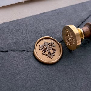 vintage interlocked monogram gold wax seal on black envelope