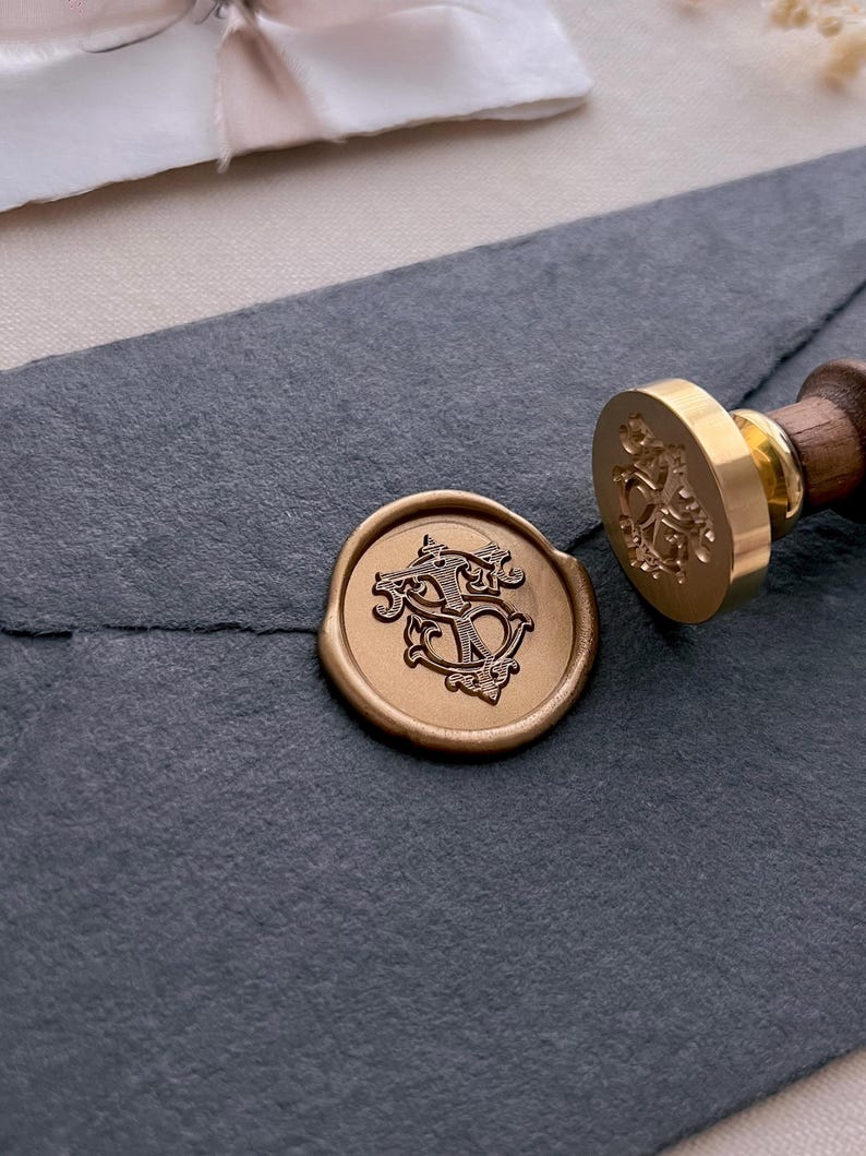vintage interlocked monogram gold wax seal on black envelope