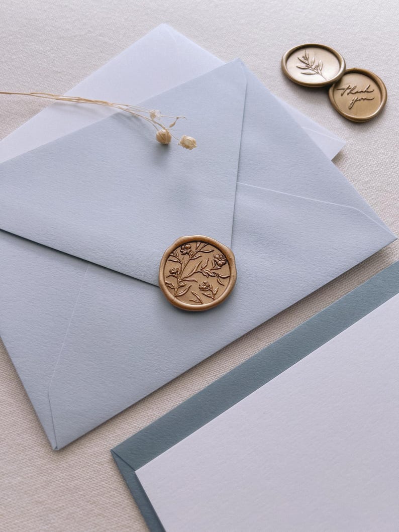 light blue envelope with gold floral wax seal