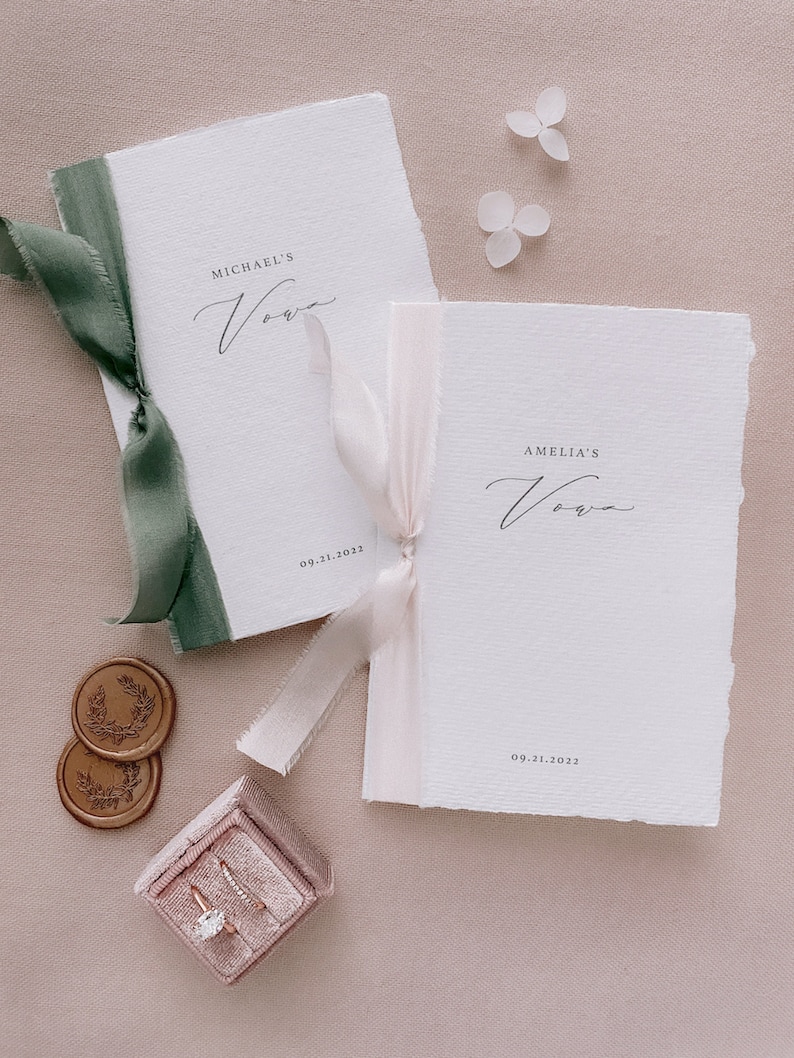 Set of 2 white handmade paper vow books printed with personalized names and date, tied in olive green and nude silk ribbons