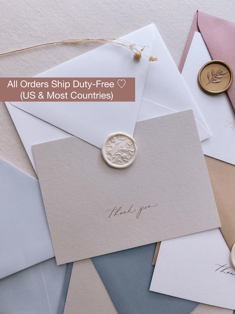 gold foil thank you beige note card with white envelope and white floral wax seal