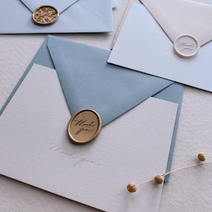 gold foil beige thank you card with dusty blue envelope and gold thank you wax seal