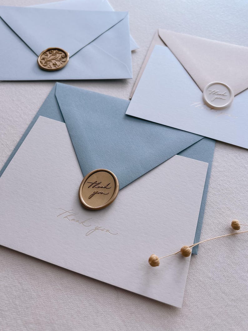gold foil beige thank you card with dusty blue envelope and gold thank you wax seal