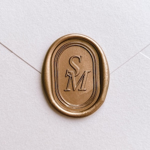 Oval border design personalized initials gold wax seal on a white envelope