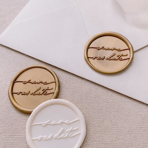 Calligraphy script Save our Date wax seals in gold and off-white on white envelope