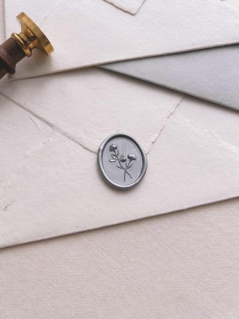 silver floral oval wax seal with 3D engraving details on white envelope