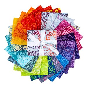 May include: A collection of colorful fabric squares arranged in a circular pattern. The fabrics feature vibrant batik designs in shades of red, orange, yellow, green, blue, and purple. A central bundle is tied with a white ribbon.