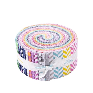 May include: A roll of colorful fabric with a variety of patterns, including chevron, polka dots, and floral designs. The fabric is tied with a white ribbon and the label "Riley Blake Designs" is visible.