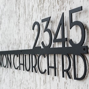 May include: Black metal house number sign with the number 2345 and the street name "UNION CHURCH RD" in all caps.
