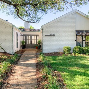 May include: A white brick house with a green door and a walkway leading to the front entrance. The house number is 2209 Stone Creek Dr.