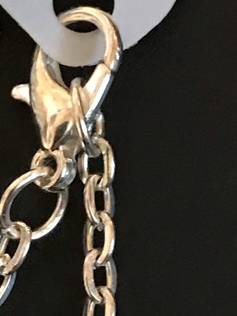 May include: Silver chain with a lobster clasp closure.