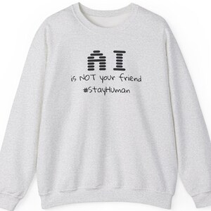 May include: A gray sweatshirt with the text "AI is NOT your friend #stayHuman" printed on the front.