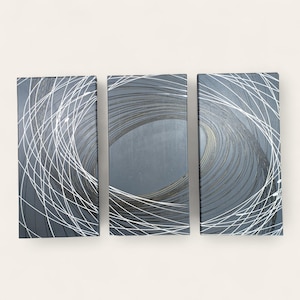 May include: A set of three rectangular wall art pieces. Each piece features a dark gray background with a swirling pattern of white lines. The central piece has a gold-toned center.