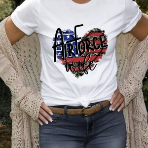 May include: White t-shirt with a red, white, and blue heart design that says "Air Force Wife".