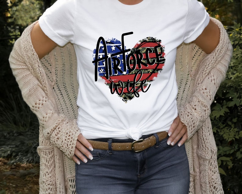 May include: White t-shirt with a red, white, and blue heart design that says "Air Force Wife".