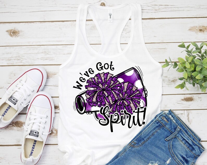 Op de afbeelding: Wit tanktop met een afbeelding van een paarse en witte cheerleading-megaphone. De megafoon heeft witte stippen en de tekst "We've Got Spirit!" in zwart.
