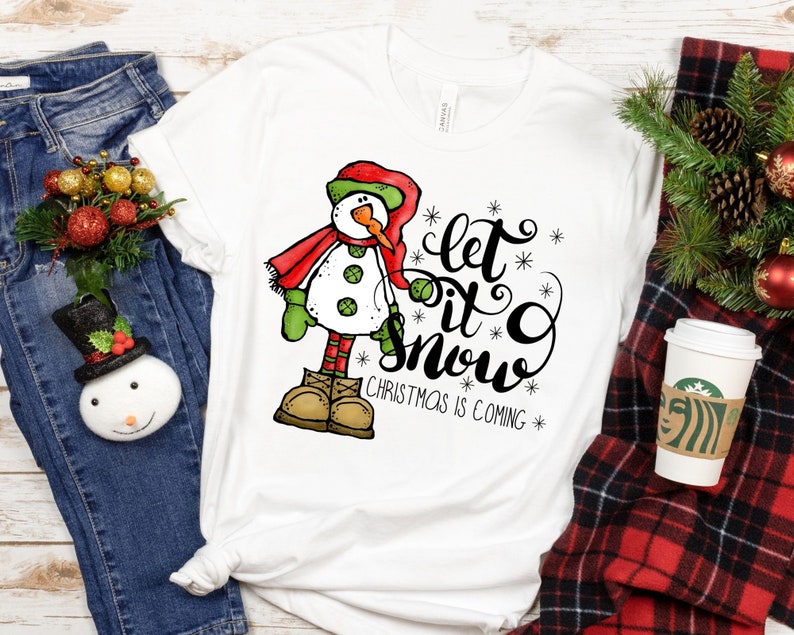 May include: White t-shirt with a cartoon snowman and the text "Let it snow Christmas is coming".