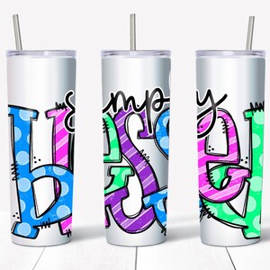 May include: Three stainless steel tumblers with a white background and colorful lettering that reads "simply blessed". The letters are outlined in black and have a variety of patterns, including polka dots, stripes, and zigzags.
